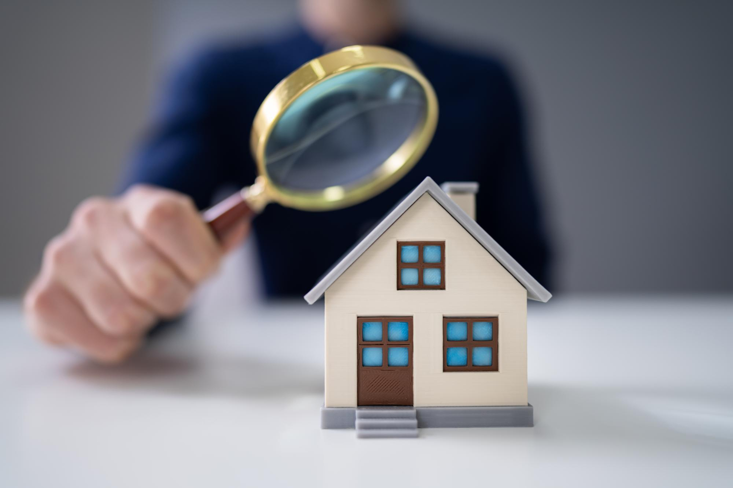 Un professionnel de l'immobilier regarde à la loupe les caractéristiques d'une maison